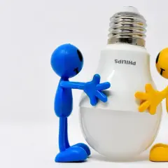 Due pupazzi, uno blu e uno giallo, abbracciano una lampadina LED Philips. Un modo divertente per ricordare come risparmiare energia in casa.