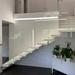 Moderna scala a sbalzo con parapetto in vetro, illuminazione integrata e un'elegante balaustra. Perfetta per il vano scale di una villa moderna.