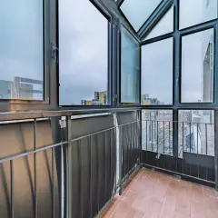 Balcone con vista sulla città, caratterizzato da ampie finestre con infissi neri che incorniciano il panorama urbano.