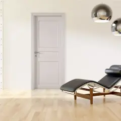 Un ambiente minimalista con porte bianche, pareti tortora, una chaise longue in pelle nera e due lampade a sospensione sferiche.