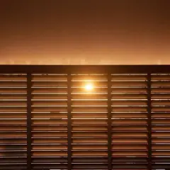 Luce solare filtrata da veneziane in legno, ideale per il calcolo risparmio energetico schermature solari.