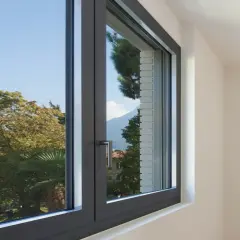 Finestra in alluminio con vista su alberi e montagne. Utile per chi cerca come regolare vecchi infissi in alluminio.