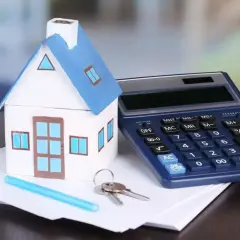 Modello di casa, calcolatrice e chiavi su fogli. Calcolo dell'IVA su infissi per la tua nuova casa.