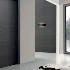 Porta moderna in legno scuro e finestra con infisso grigio. La trasmittanza termica, unità di misura fondamentale per l'efficienza energetica, è un valore da considerare.