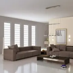 Soggiorno moderno con divani color tortora e grigio, tavolino scuro, specchio alto e grandi finestre.