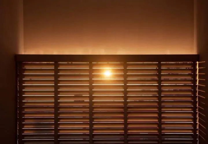 Luce solare filtrata da veneziane in legno, ideale per il calcolo risparmio energetico schermature solari.