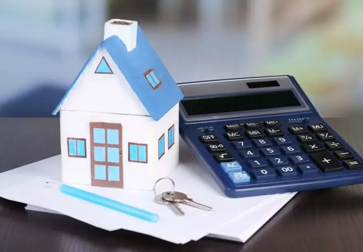 Modello di casa, calcolatrice e chiavi su fogli. Calcolo dell'IVA su infissi per la tua nuova casa.