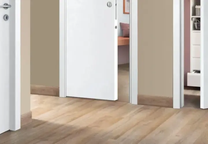 Corridoio con pavimento chiaro e porte interne bianche che creano un ambiente luminoso e moderno.