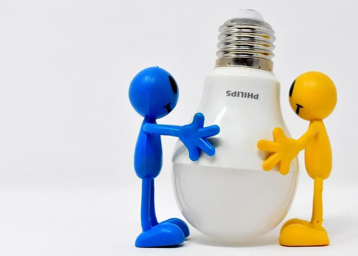 Due pupazzi, uno blu e uno giallo, abbracciano una lampadina LED Philips. Un modo divertente per ricordare come risparmiare energia in casa.