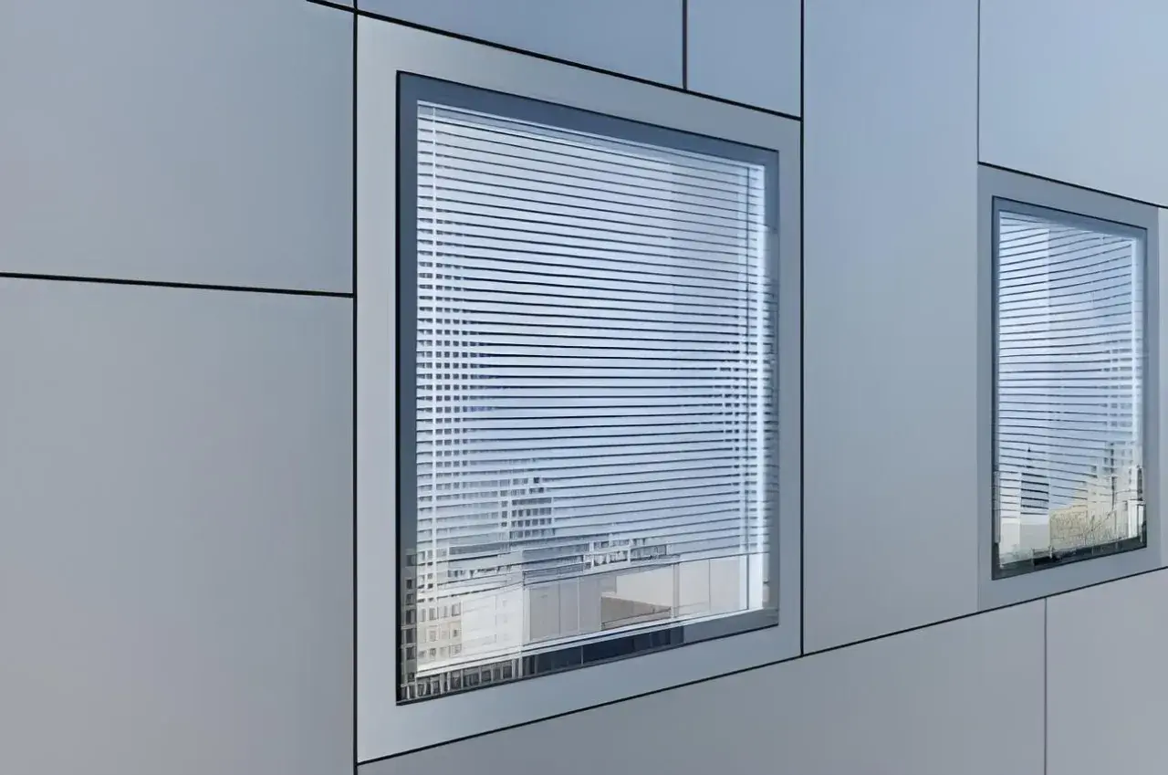 Finestra filo muro interno con veneziane, riflessi di un edificio moderno.