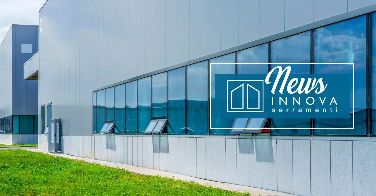 Edificio moderno con ampie vetrate riflettenti e infissi industriali. Logo "News Innova serramenti" sovrapposto.