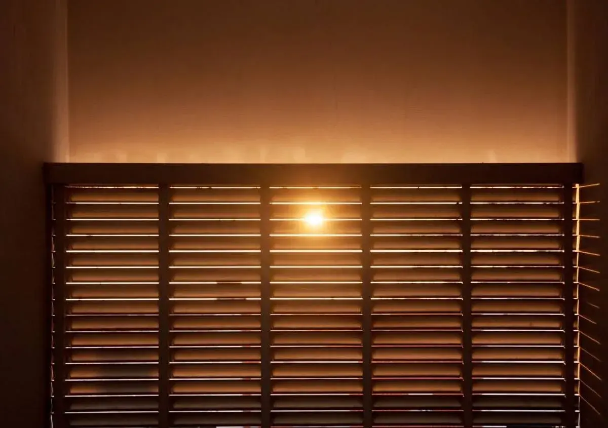 Luce solare filtrata da veneziane in legno, ideale per il calcolo risparmio energetico schermature solari.