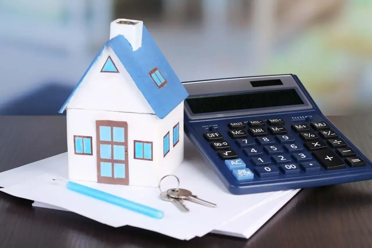 Modello di casa, calcolatrice e chiavi su fogli. Calcolo dell'IVA su infissi per la tua nuova casa.
