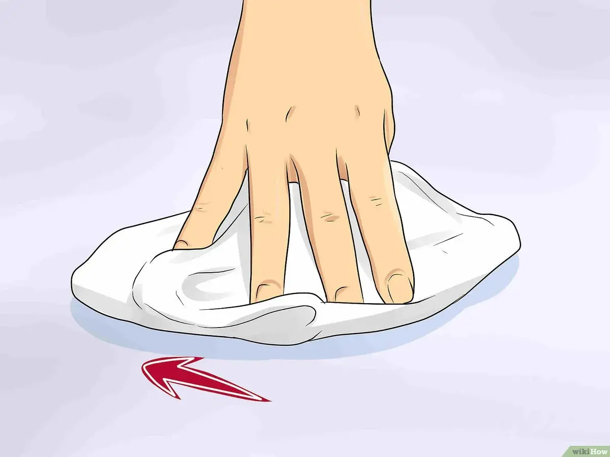 Mano che pulisce una superficie con un panno bianco, mostrando come togliere graffi dal vetro con un movimento circolare.