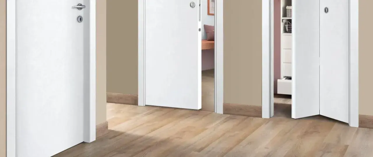 Corridoio con pavimento chiaro e porte interne bianche che creano un ambiente luminoso e moderno.