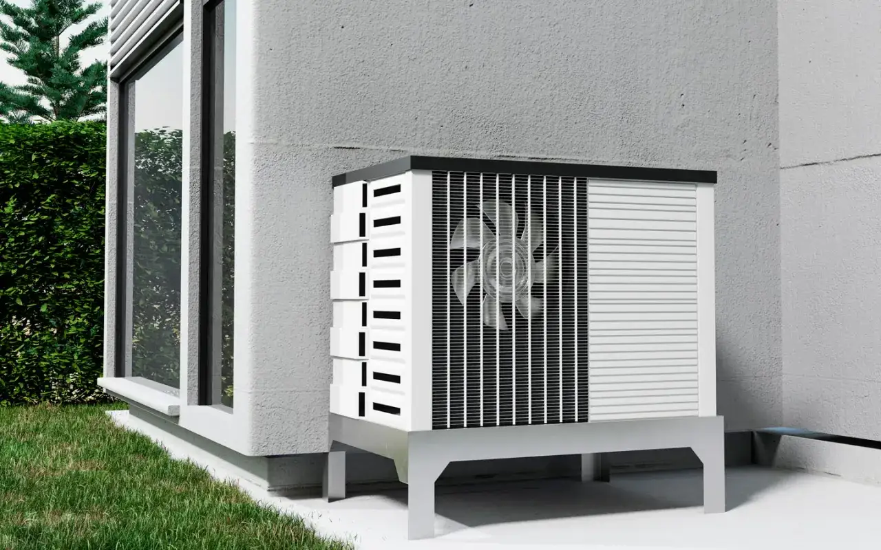 Unità esterna di pompa di calore, ideale per risparmiare gas riscaldamento. Installata accanto a una finestra, su un prato verde.